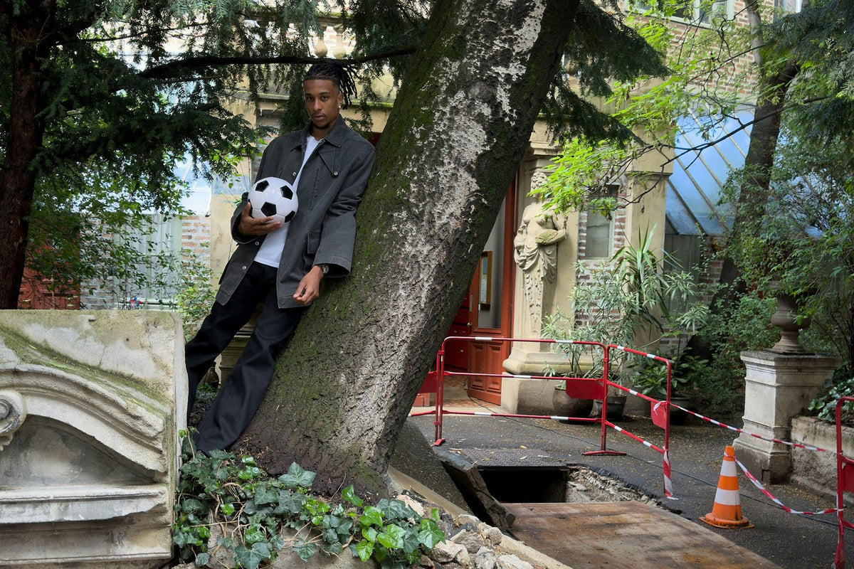 Michael Olise photographié dans un arbre, ballon en main, pour Highsnobiety.