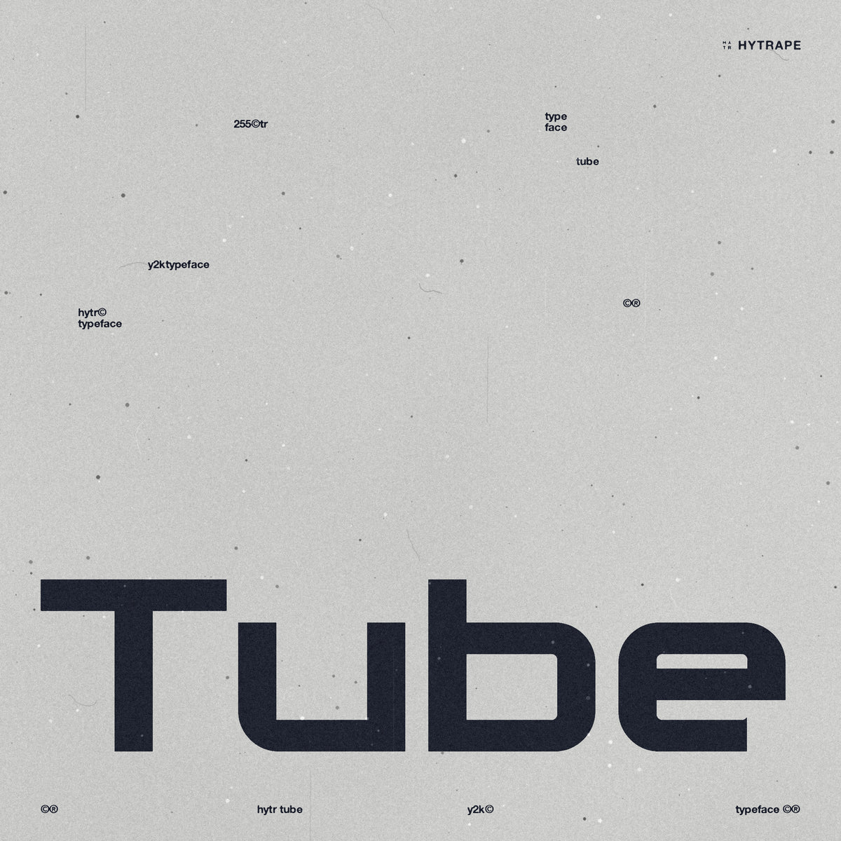HYTR Tube, police Y2K CRT par HYTRAPE : le mot Tube en grosses lettres bleu nuit sur papier gris, avec des micro-textes dispersés