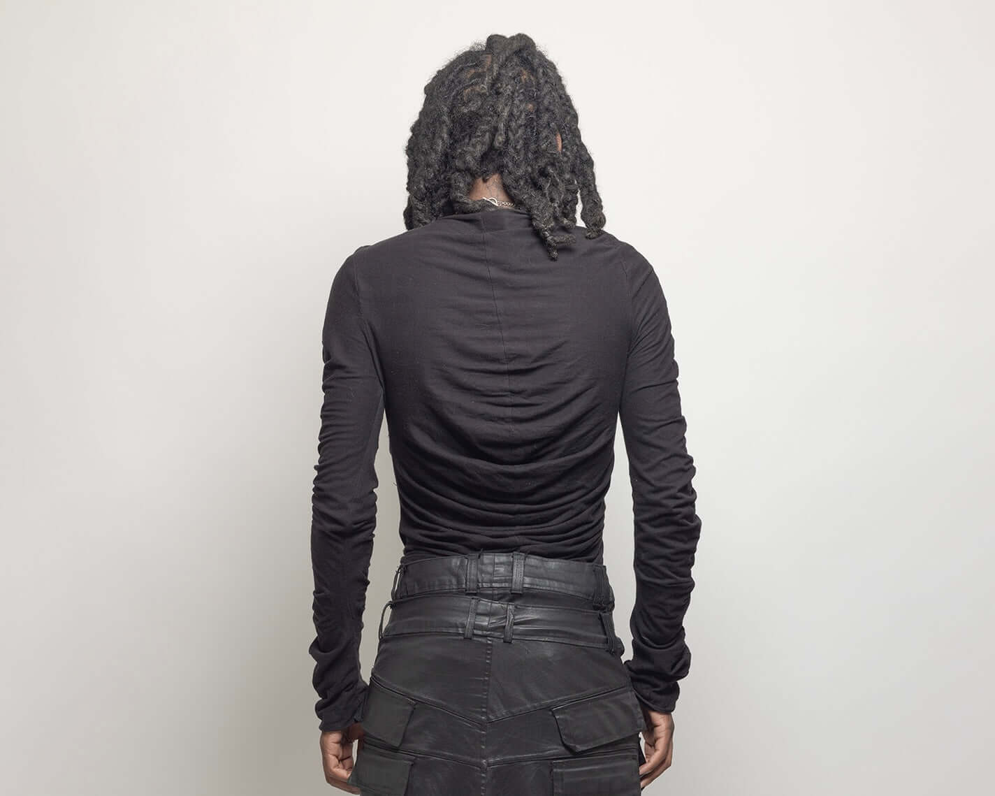 Black plissé cotton jersey top from GOES WRONG "SILHOUETTE" Collection, designed in Paris, worn by a model with back view.